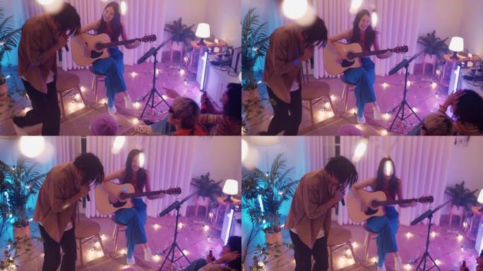 快乐的年轻朋友们在共同的公寓聚会，一起唱歌，而他们的朋友弹吉他。