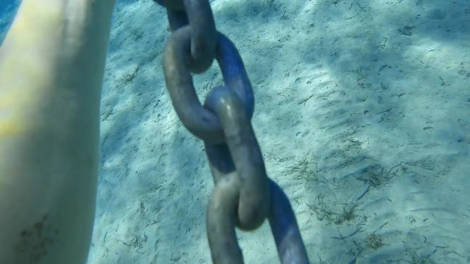 POV潜水员在海中拖着一条链子