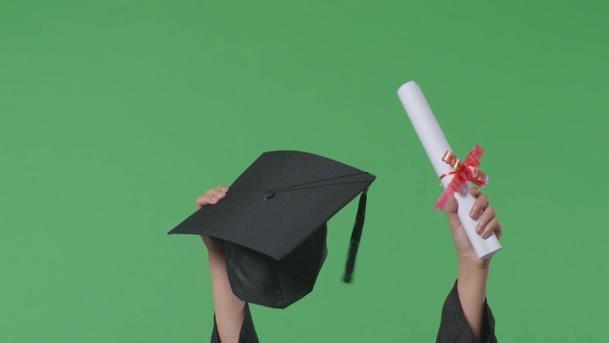 在绿幕背景工作室的毕业典礼上，一名女学生将帽子和文凭举在空中