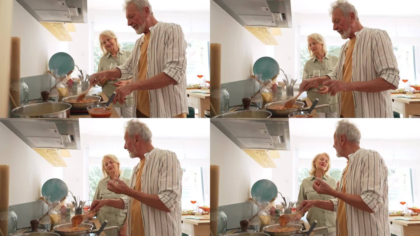 有爱心的老年妻子在厨房里帮助丈夫