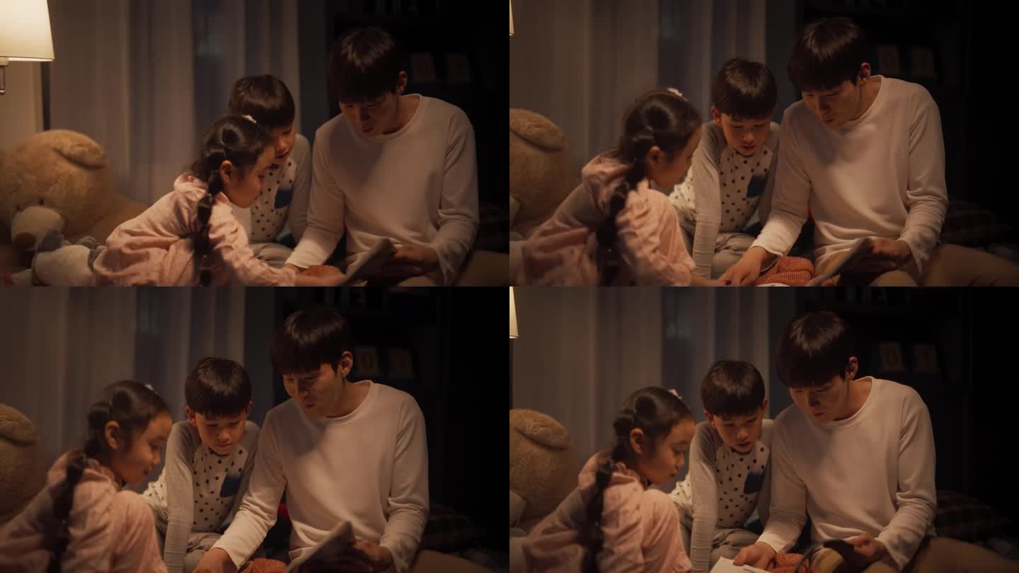 韩国父亲在睡觉前给他可爱的孩子们读童话故事。年轻英俊的爸爸照顾他的孩子，晚上在家读一本书的故事