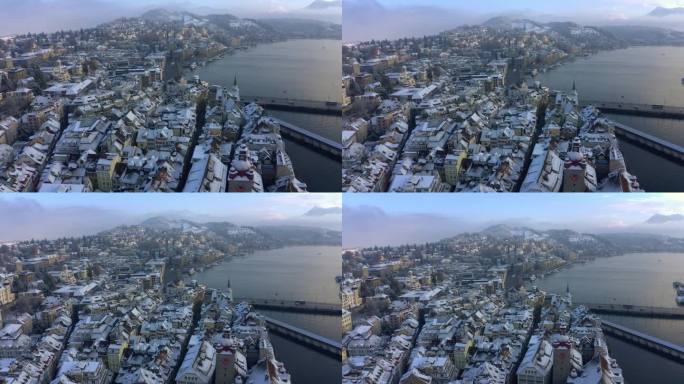 无人机拍摄的瑞士卢塞恩，田园诗般的晚冬风景，桥梁交通和积雪覆盖的建筑物