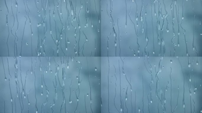 雨滴顺着玻璃流下来。窗外下着大雨，天气越来越糟。慢镜头，蓝色背景
