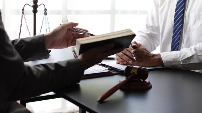 商人与律师或法律顾问讨论文件、合同、法律协议的签署。