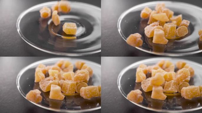 结晶的姜糖慢慢地落在玻璃碟子上。甜的健康食品