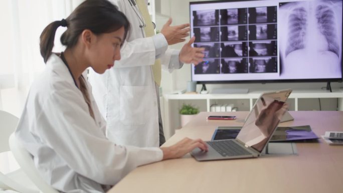 一个内科医生和护士心脏病专家小组在医院开会，分析了电视屏幕上病人的x光片。
