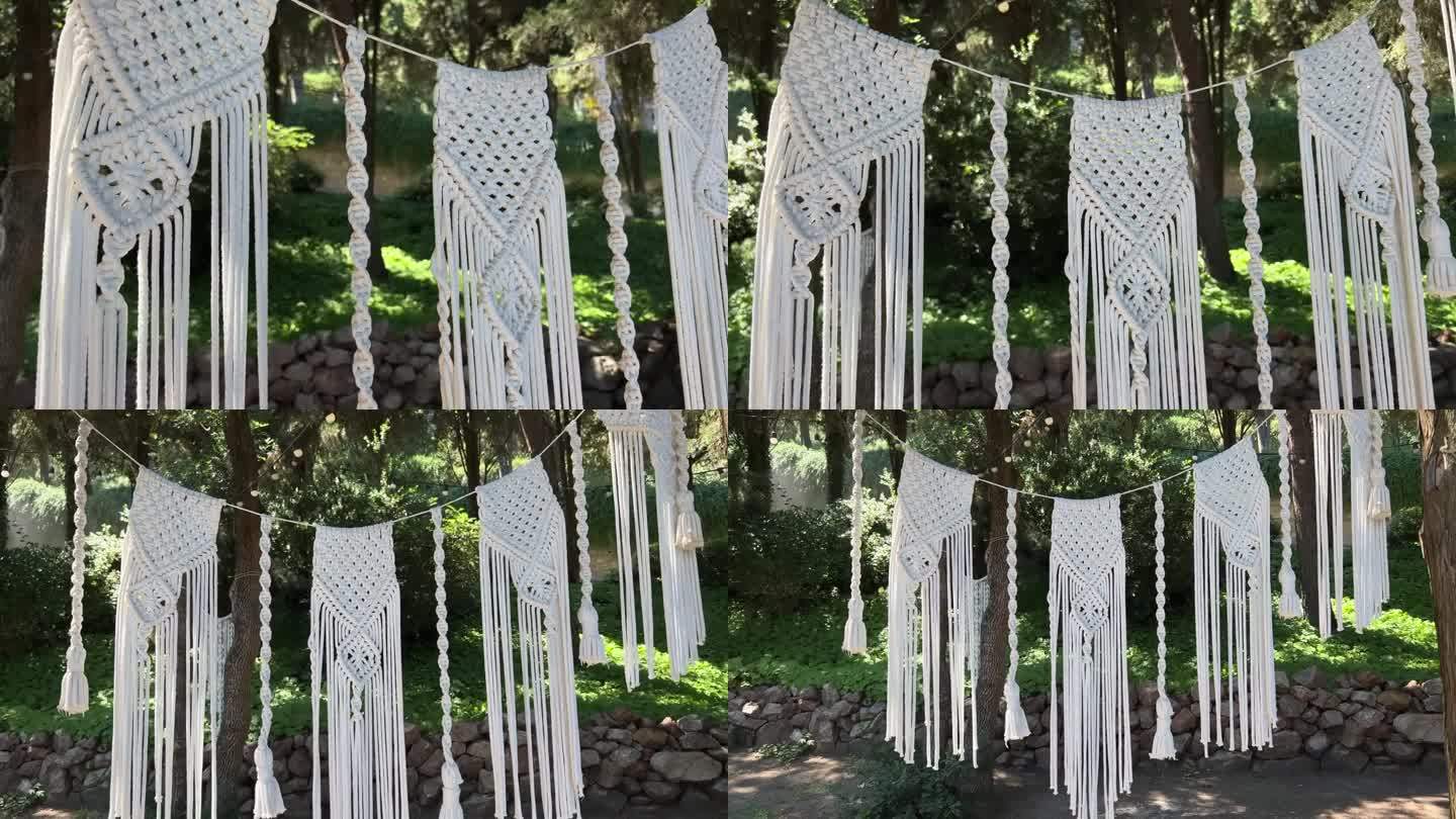 在室外的绿色热带花园中，用白色的编织线编织出花环。民族棉装饰