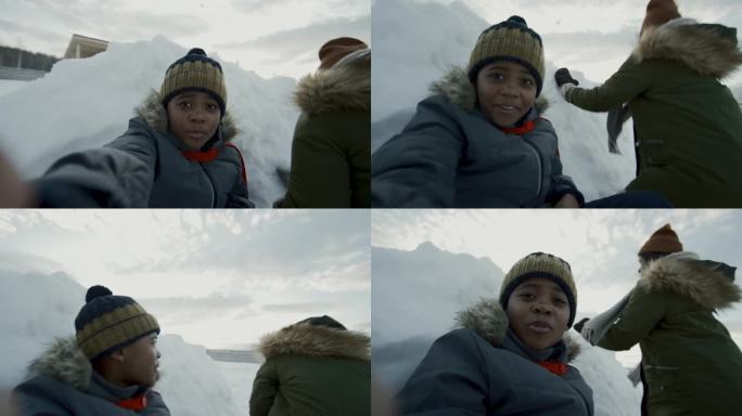 非裔美国孩子在智能手机上和朋友一起打雪仗