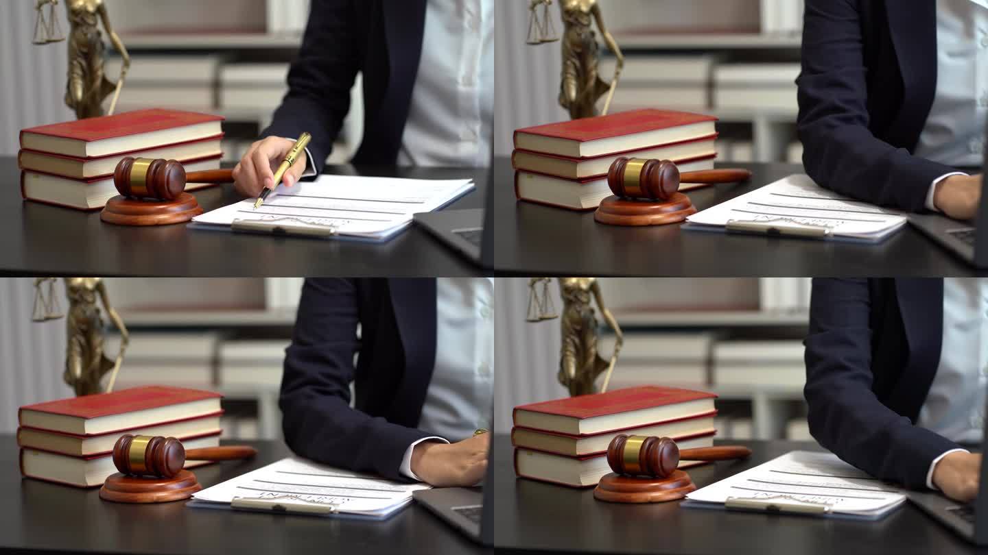 正义与法律概念。女法官在法庭上敲着木槌，在阳光下的木桌上用数码平板电脑工作。