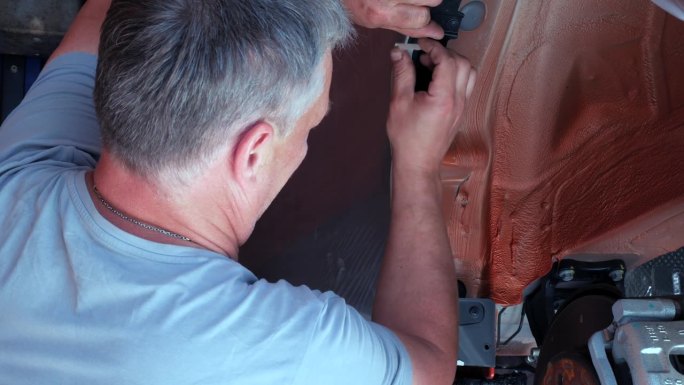 车身维修技师将胶带粘在车身上。