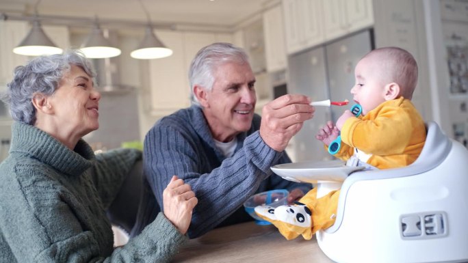 宝宝，和爷爷奶奶一起在家里的桌子旁吃早餐和粥，营养和孩子的成长。家庭，厨房和健康餐，饥饿的孩子在高脚