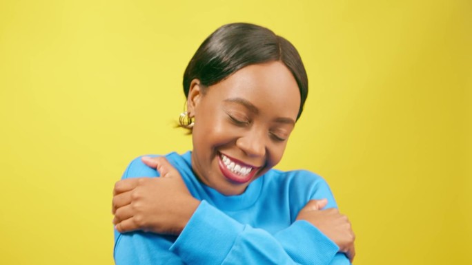 黑人妇女摩擦手臂，拥抱，自爱概念，黄色工作室背景