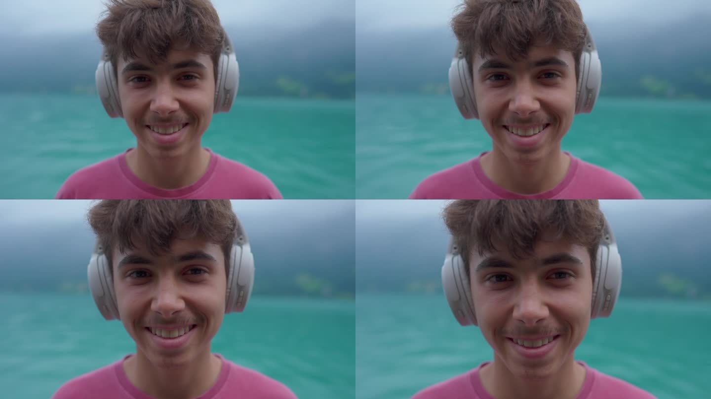 英俊的少年戴着耳机，连接到湖边场景的声音，在音频之旅中直接看相机