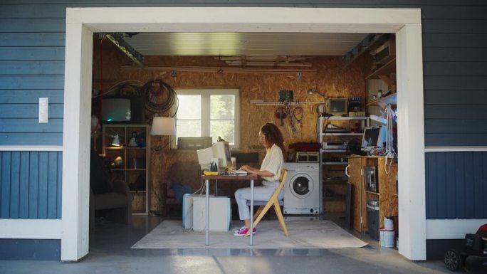 西班牙裔女性开发人员在复古车库的旧台式电脑上编程。年轻女性在九十年代致力于创新的在线服务创业公司。怀