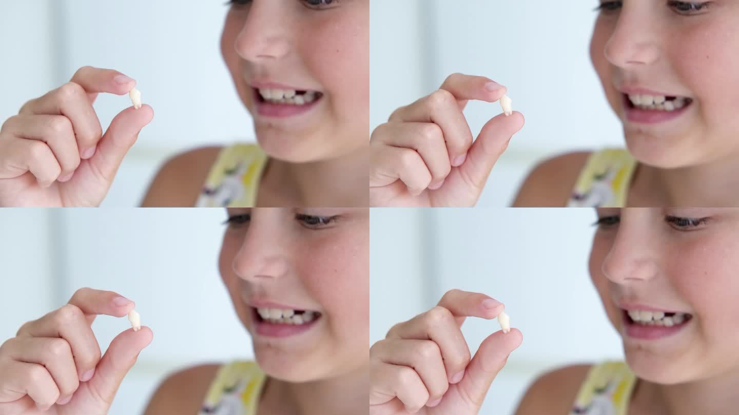 这个女孩手里拿着乳牙。拔牙后孩子开心。