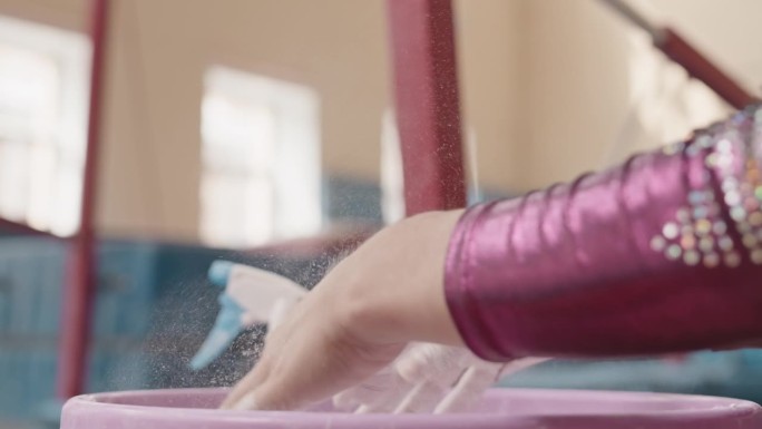 体操运动员在做艺术动作前在手上擦粉笔粉