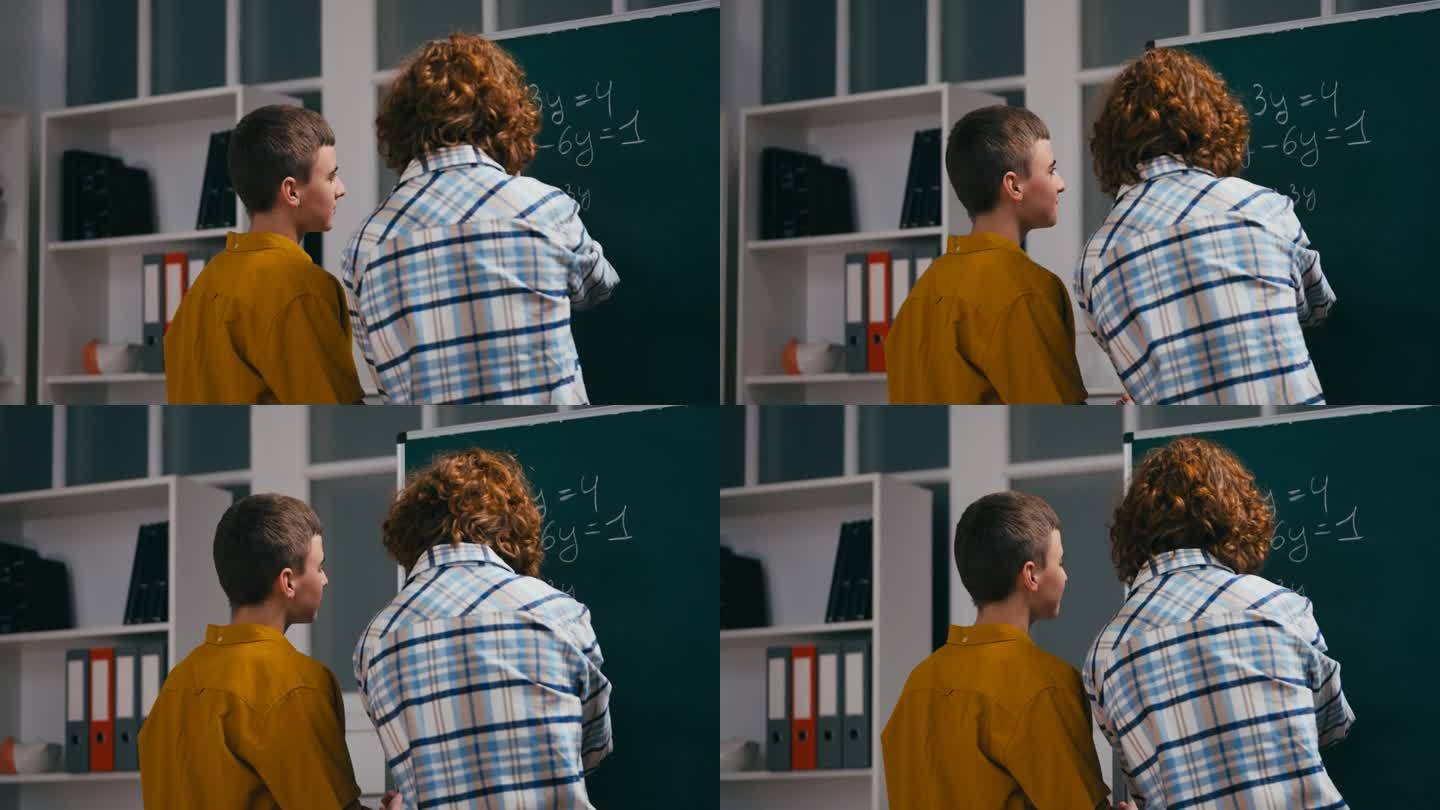 代数课上，十几岁的男孩在黑板旁帮同学做数学题