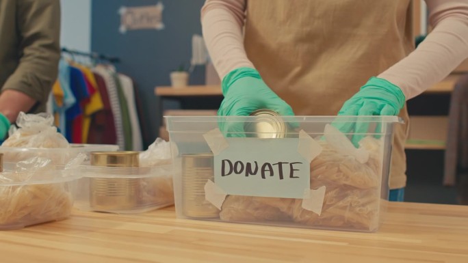 慈善项目协调人将食物放入捐款箱