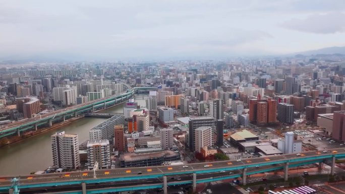 阴天的福冈市景。汽车在河上的桥上行驶