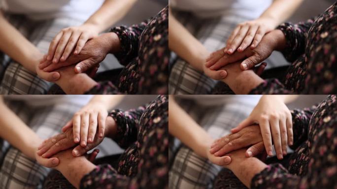 年轻女子抚摸着老奶奶的手，特写