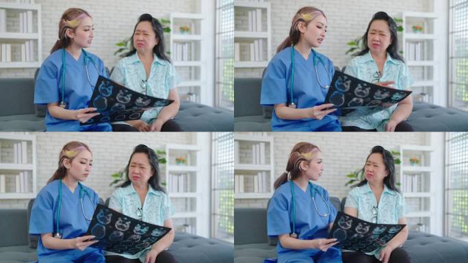 年轻的亚洲女医生向老年病人展示x光片，向诊所的老年妇女解释x光片。女护士拿着x光片向咨询病人解释