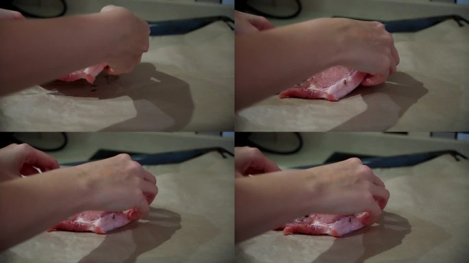 女人的手把多汁的生猪排放在烤纸上。