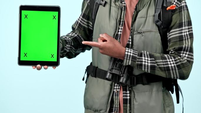 平板电脑绿色的屏幕，背包客的手指向徒步旅行者的GPS，品牌标志设计或模型空间。蓝色背景的工作室跟踪标