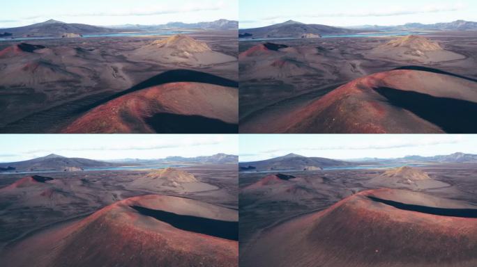 航拍:在一个晴朗的日子里，冰岛高地上休眠的、充满活力的红黑相间的火山倒映。