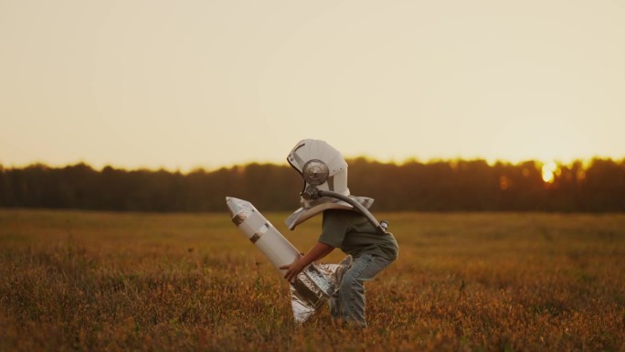 小宇航员在太空中发射火箭，带着宇航员头盔的可爱男孩把玩具火箭扔了起来