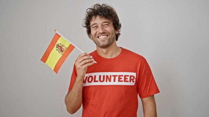 年轻的西班牙裔男子激进分子在孤立的白色背景上举着西班牙国旗
