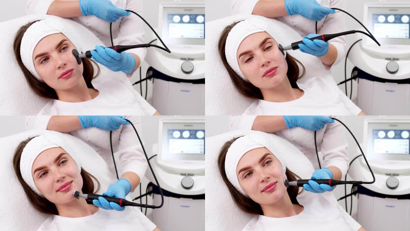 微电流治疗期间，一位年轻女性的脸部特写。电刺激面部的程序，嫩肤，抗皱。青春的理念与现代美容技术。