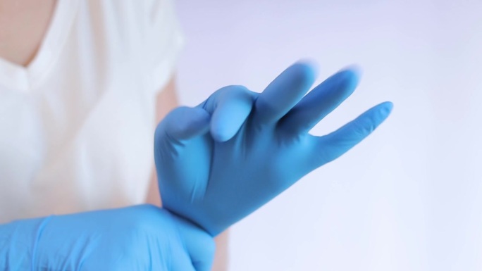 双手戴医用乳胶手套。医生或护士戴丁腈防护手套