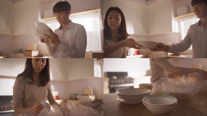 可爱的韩国夫妇在搬进明亮的新公寓后打开厨房的盘子。成功的房主愉快地作为一个团队工作，打开他们的物品