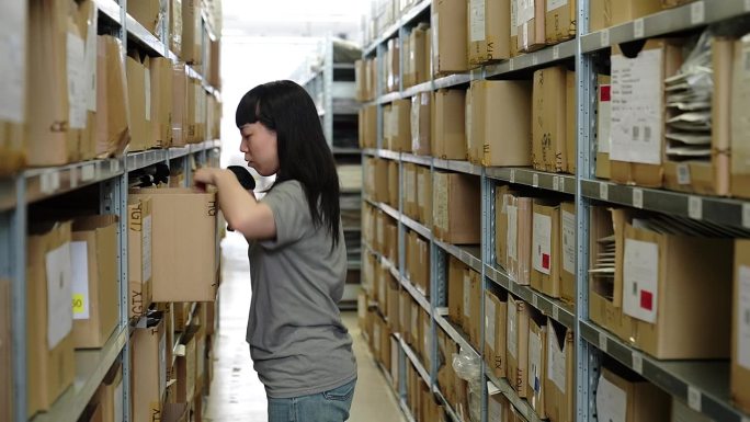 在配送中心仓库工作的年轻亚洲女工