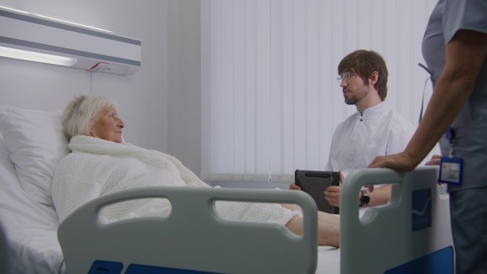 男医师在病房用药片咨询女老年病人