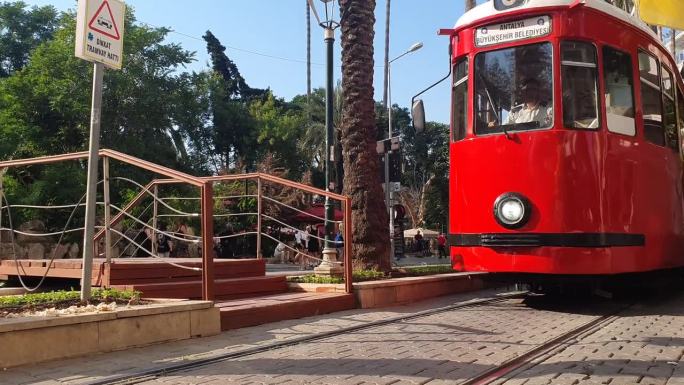 红色的土耳其人沿着安塔利亚老城的街道行驶着老式电车