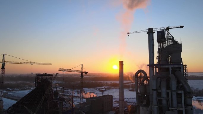 高强混凝土厂房结构的水泥厂及工业生产区塔吊夜景鸟瞰图。制造和全球产业理念