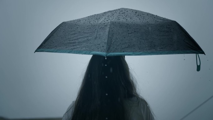 一个女人在雨中打着伞