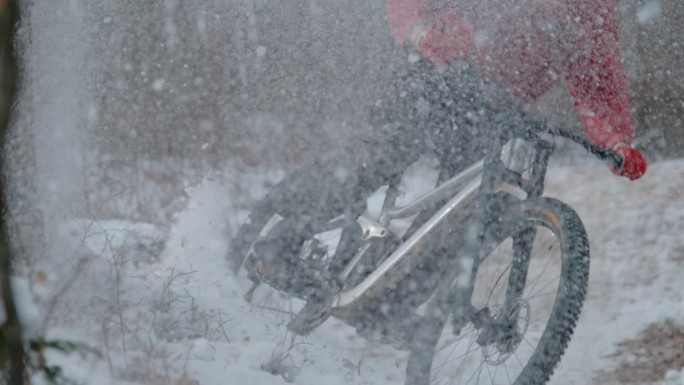 慢动作，DOF，特写:MTB车手赛车和漂流沿着雪道