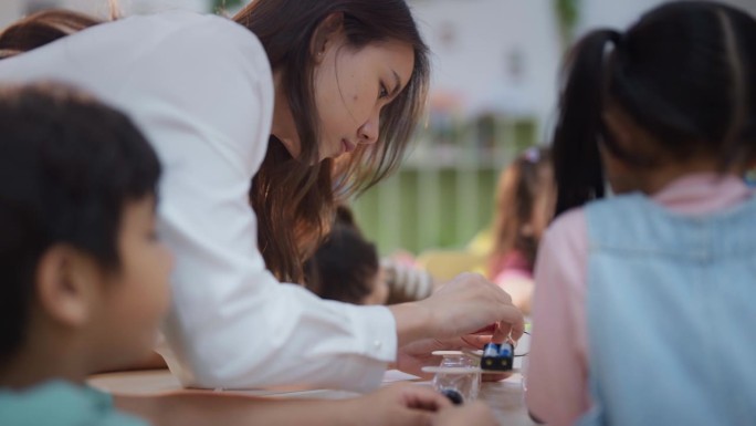 这位迷人的老师在课堂上帮助学生，看起来很专注。