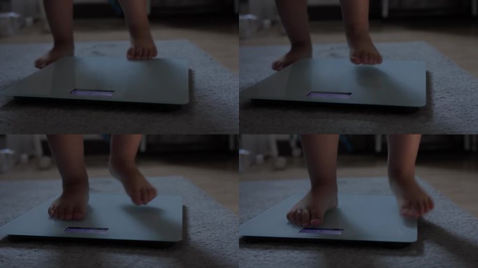 小婴儿赤脚站在家里地毯地板上的体重秤上。儿童体重控制概念。