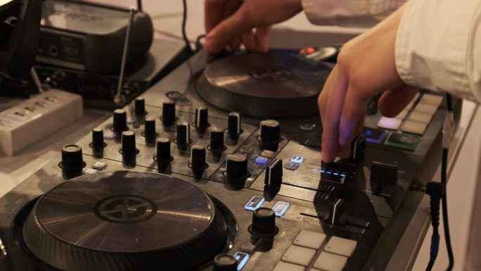 DJ播放音乐使用DJ混音控制器在夜间聚会