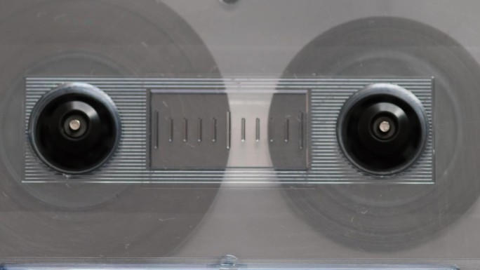磁带录音机中一个老式录音带的特写被重绕，旋转到开头。80年代的音响设备。旧电影录音带特写。有选择性的