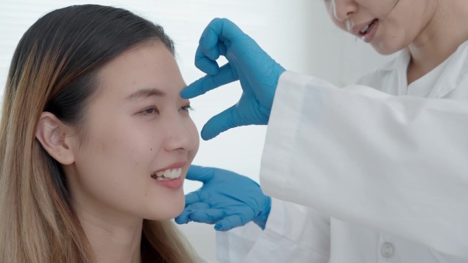 整容手术，美容，外科医生或美容师触摸女人的脸，涉及改变眼睛形状的外科手术，医疗援助，眼睑手术，双眼皮
