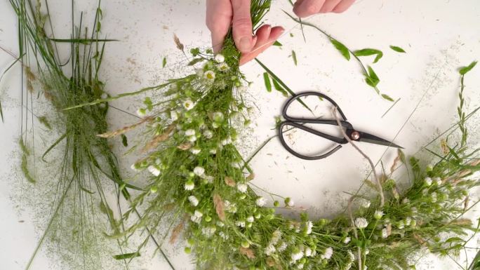 为伊万·库帕拉的盛宴编织花圈的花艺大师班。妇女用新鲜的草药和鲜花编织花环，这是异教徒的象征，冬至日。