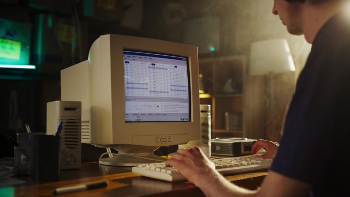 白人男性股票交易员使用旧台式电脑与金融烛台图表在复古车库。90年代人进场前分析市场订单，开始投资基金