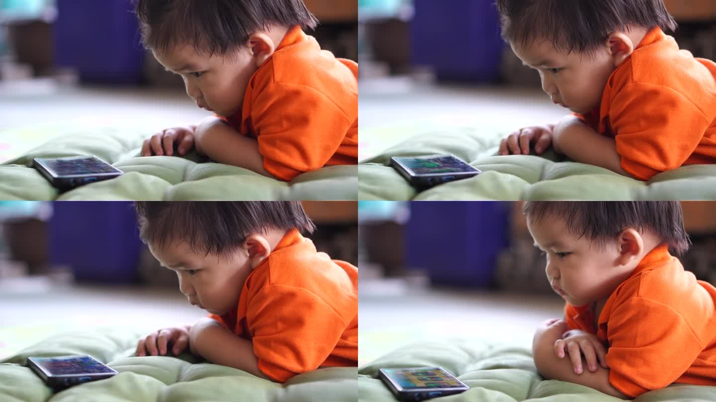 儿子躺在屋外看他的智能手机。