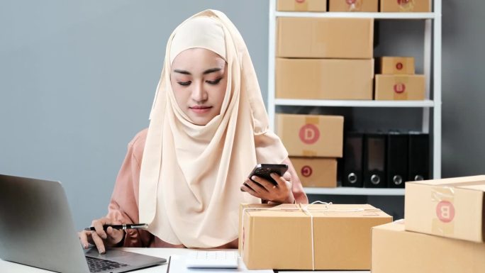 美丽的穆斯林妇女在家网上销售，企业主，创业小生意的概念