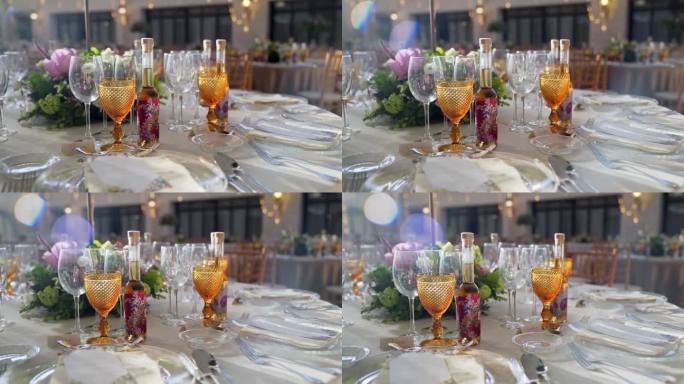 用鲜花、酒杯和礼品酒装饰婚宴桌。缓慢旋转相机运动。