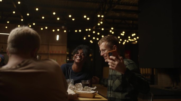 多种族夫妇在餐厅朋友聚会上用手机自拍，美好的回忆